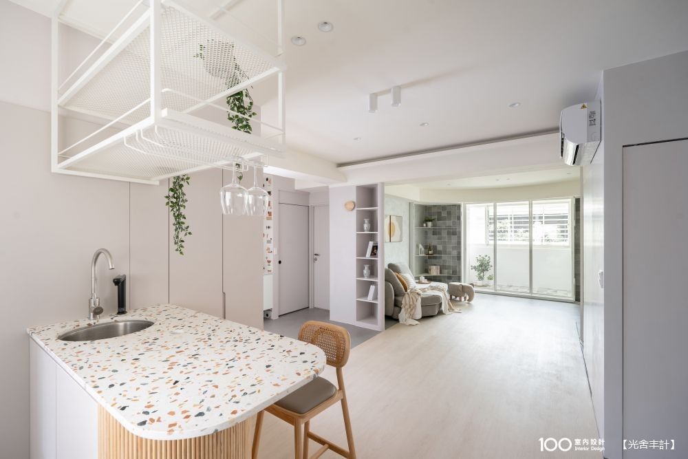 ▲彩色水磨石檯面呼應了客衛浴洗手台牆繽紛的積木磚，原木立面則讓開放式餐廚區添一分溫馨。